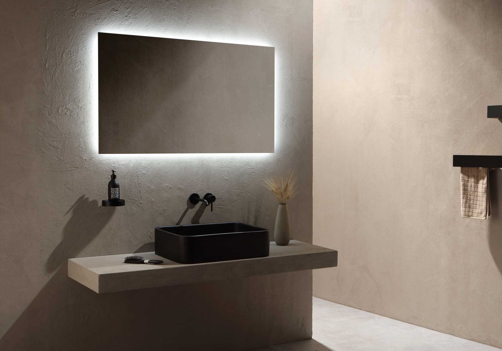 Modern bathroom setup with a black sink and illuminated mirror.